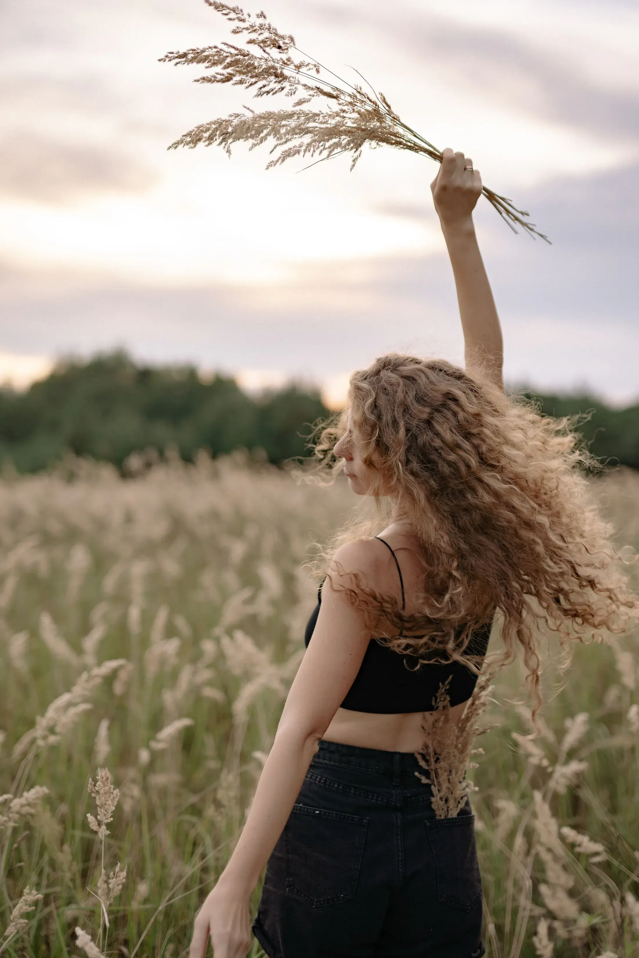 Woman with loose curly hair enjoying the sunset